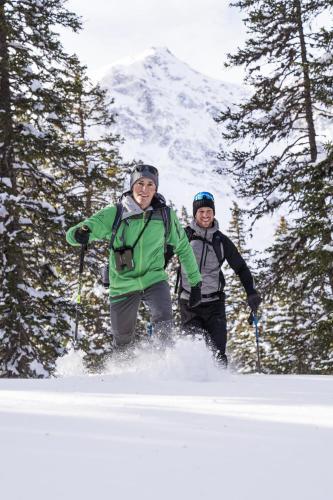 two people are standing in the snow on skis at Hüttenzauber in Taxenbach