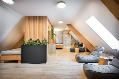 a living room with a staircase with a couch and a plant at Hotel SKANZEN in Velehrad