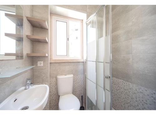 a bathroom with a toilet and a sink and a window at HOUZE_4 room flat in Central Lisbon in Lisbon