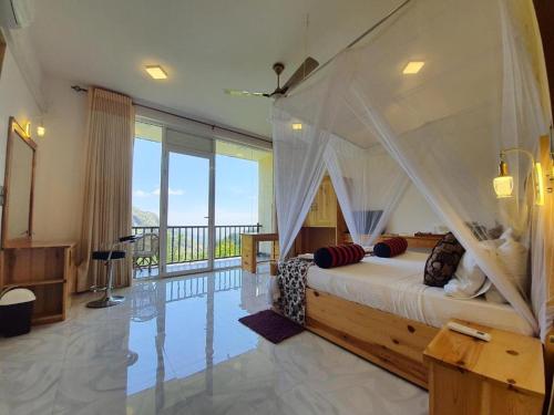 Schlafzimmer mit Himmelbett und Balkon in der Unterkunft Edge Resort in Modakandiya