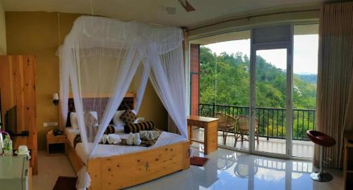 Schlafzimmer mit Himmelbett und Balkon in der Unterkunft Edge Resort in Modakandiya