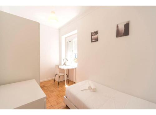 a white room with a bed and a desk at HOUZE_4 room flat in Central Lisbon in Lisbon