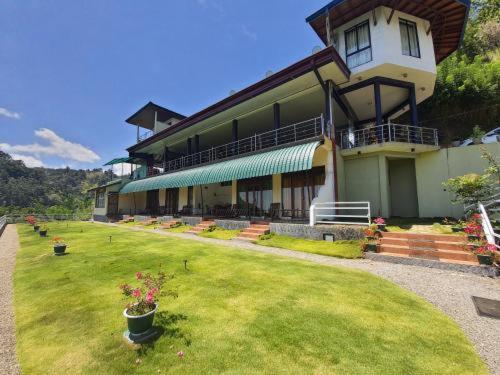 duży dom z trawnikiem przed nim w obiekcie Edge Resort w mieście Modakandiya