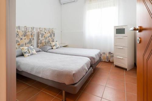 a bedroom with two beds and a window at Bombana Beach Apartments in Fontane Bianche