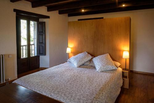 1 dormitorio con 1 cama grande y 2 almohadas en Can Feló, en Tavertet