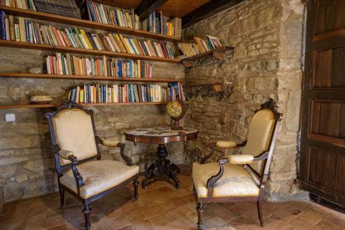 una habitación con 2 sillas y una mesa con libros en Can Feló, en Tavertet