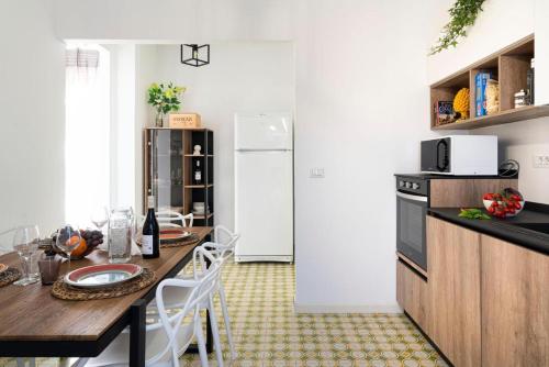 a kitchen with a table and a refrigerator at Bombana Beach Apartments in Fontane Bianche