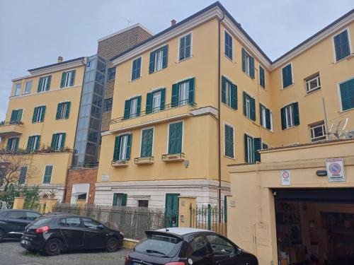 un gran edificio amarillo con coches estacionados frente a él en Gianicolo Sweet Home, en Roma