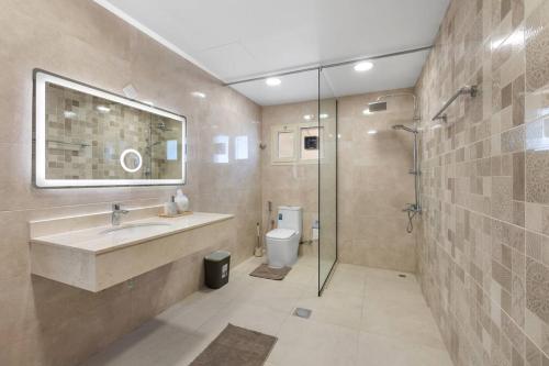 Luxury Emirates Private Villa in Dubai Jumeirah في دبي: حمام مع حوض ودش ومرحاض