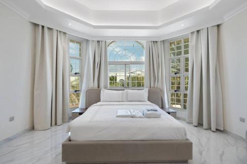 a bedroom with a large white bed and windows at Luxury Emirates Private Villa in Dubai Jumeirah in Dubai