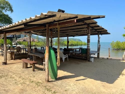 a pavilion on the beach with tables and benches at Baan Plai Laem Homestay at Koh Paluay in Koh Phaluai