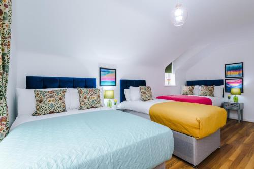 a bedroom with two beds and a yellow ottoman at Charming 2Bed Retreat in Historic Coventry in Coventry