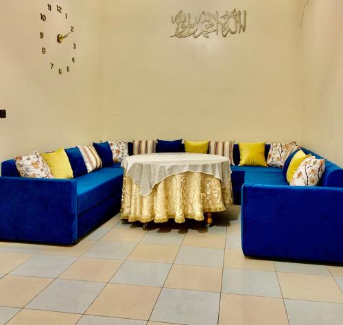 a living room with two blue couches and a table at Al houceima in Al Hoceïma