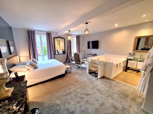 a bedroom with a large bed and a bath tub at Domaine de Joinville in Eu