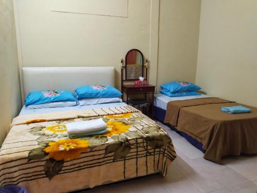 ein Schlafzimmer mit 2 Betten und Handtüchern darauf in der Unterkunft Homestay Haji Hamid in Pantai Cenang