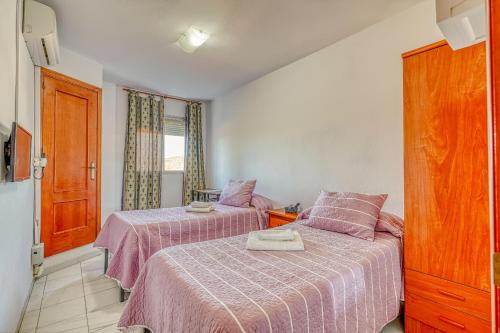 a bedroom with two beds with pink sheets at Ochomin Hostel in San Martín del tesorillo