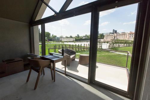 a room with a table and chairs and a large window at Castel Mimi Wine Resort in Bulboaca