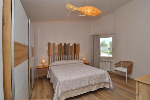 a bedroom with a bed and a chair and a window at Amoreddu in San Teodoro