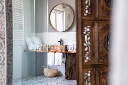 a bathroom with a mirror and a sink with towels at Hotel rural Finca Vivaldi Nature & Spa in San Miguel de las Dueñas