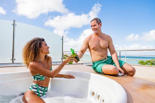 a man and a woman sitting in a bath tub at Aquaria Natal Hotel in Natal