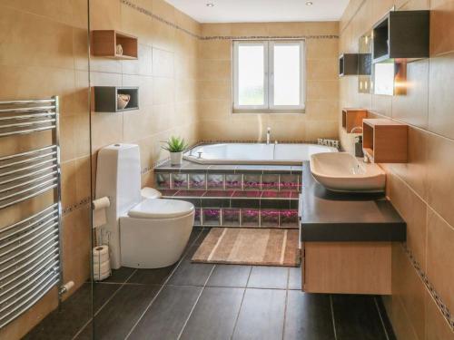 uma casa de banho com 2 lavatórios e uma banheira em Luxurious 5 bedroom house with games room em Kingholm Quay