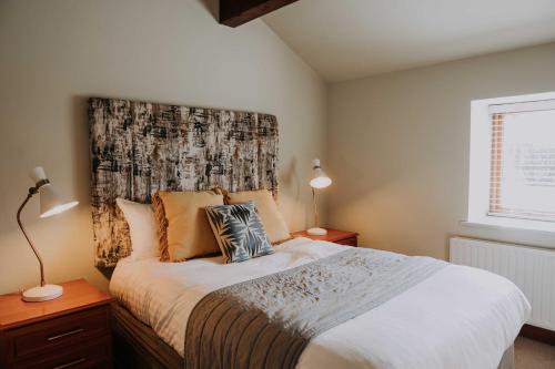 a bedroom with a large bed with a large headboard at Pattys Barn Holiday Cottages, Cabins and Venue Hire in Cockerham