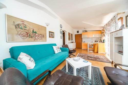 a living room with a blue couch and a table at Harmony Budva Apartment in Budva