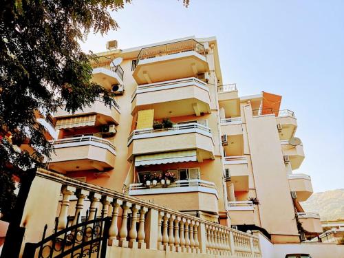 a tall yellow building with balconies and a staircase at Harmony Budva Apartment in Budva