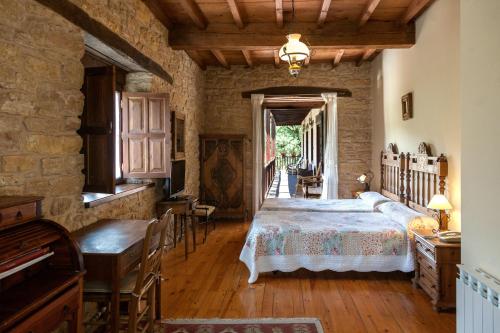 1 dormitorio con 1 cama, mesa y sillas en Paraiso del Bierzo, en Las Herrerías