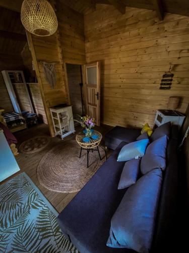 - un salon avec un canapé bleu dans une cabine dans l'établissement Hulajdusza, à Gościno