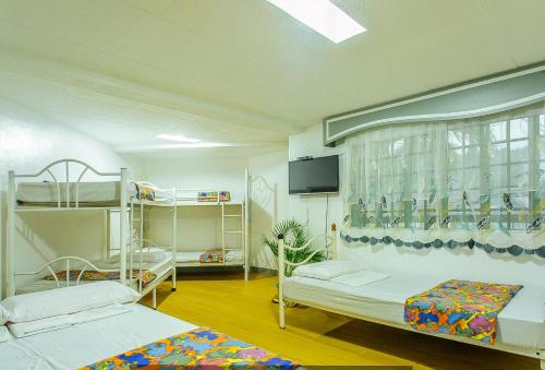 Cette chambre comprend 2 lits superposés et une télévision à écran plat. dans l'établissement RedDoorz @ Yahweh Spring Retreat & Resort Laguna, à Calamba
