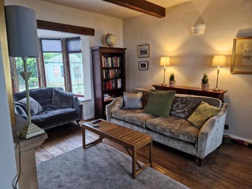 a living room with a couch and a table at Briar Cottage Guest Suite in Norwood Green, Halifax in Halifax