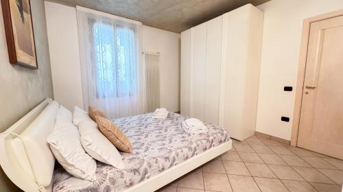 a bedroom with a bed with pillows and a window at Lady Teresa Apartment by Ca-Sa Check in Chioggia