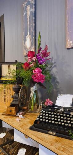 a desk with a vase of flowers and a keyboard at Hotel rural Finca Vivaldi Nature & Spa in San Miguel de las Dueñas
