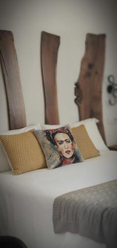 a bed with two pillows with a picture of a woman at Hotel rural Finca Vivaldi Nature & Spa in San Miguel de las Dueñas