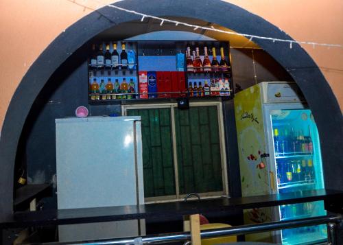 eine Bar mit einem Kühlschrank und einem Regal mit Getränken in der Unterkunft Rehoboth hotel, Apartment and Event services in Suberu Oje