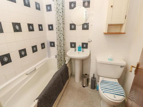 a bathroom with a toilet and a sink and a tub at Flat 2, Clifton Gardens in Southampton