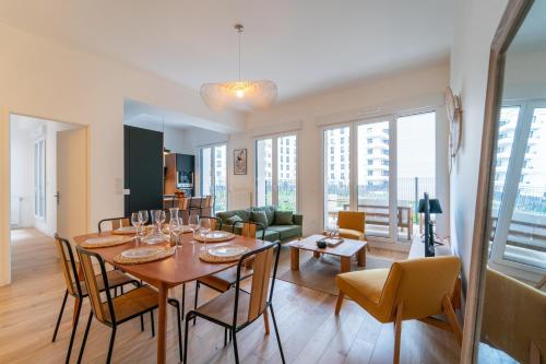 une salle à manger et un salon avec une table et des chaises dans l'établissement L'Exupéry- Parking privé et à 15min de Paris, à Saint-Ouen