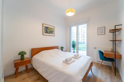 une chambre avec un lit, un bureau et une fenêtre dans l'établissement L'Exupéry- Parking privé et à 15min de Paris, à Saint-Ouen