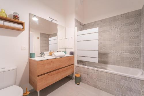 une salle de bain avec un lavabo, une baignoire et des toilettes dans l'établissement L'Exupéry- Parking privé et à 15min de Paris, à Saint-Ouen