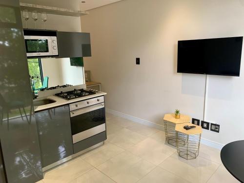 a kitchen with a stove and a sink at OAM The Paramount Rosebank Luxury One-Bedroom in Johannesburg