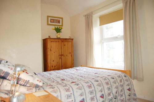 a bedroom with a bed and a window at Aelfor Cottage in Barmouth in Barmouth
