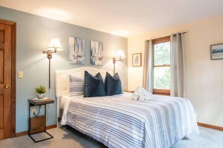 a bedroom with a large bed with blue pillows at Bring your pups to Chatham Direct access to the Cape Cod Rail Trail in Chatham
