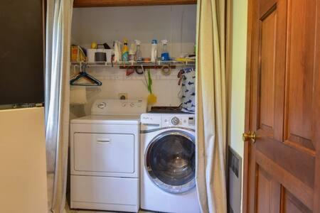 a washer and dryer in a small kitchen at Bring your pups to Chatham Direct access to the Cape Cod Rail Trail in Chatham