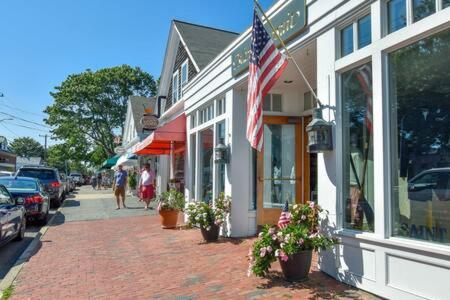 a street with a flag on the side of a building at Bring your pups to Chatham Direct access to the Cape Cod Rail Trail in Chatham