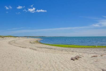 a sandy beach with the ocean in the background at Bring your pups to Chatham Direct access to the Cape Cod Rail Trail in Chatham