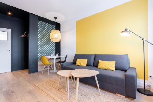 a living room with a blue couch and a table at Appartement rénové en 2023 à 10 min de Lille in Marquette-lès-Lille