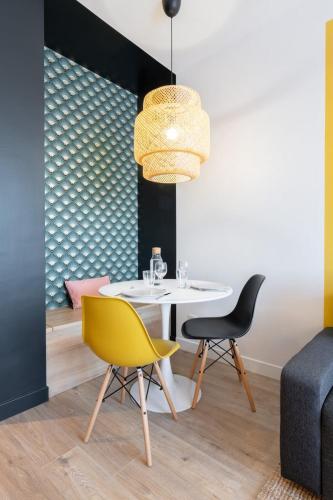 une salle à manger avec une table blanche et deux chaises dans l'établissement Appartement rénové en 2023 à 10 min de Lille, à Marcq-en-Barœul