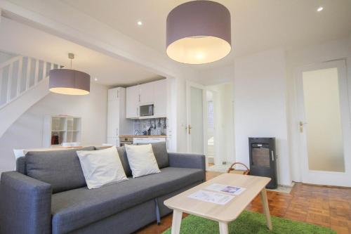 un salon avec un canapé et une table dans l'établissement Lille Wazemmes- Appartement avec balcon et vue, à Lille