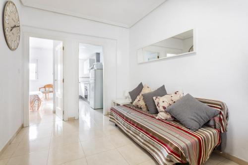 a living room with a couch and a clock on the wall at Zona Garbí in Valencia